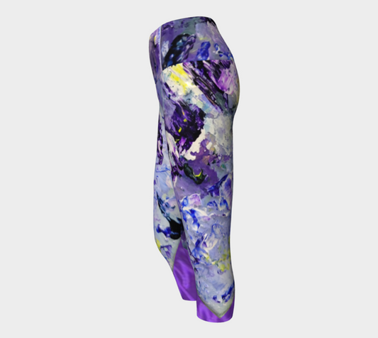 Purple abstract patterned leggings with blue, white, and yellow paint splatter details, shown from a side profile on a light gray background.